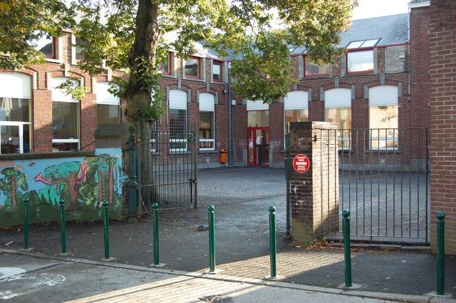 L'entrée de l'école vue depuis la cour, avec la grille