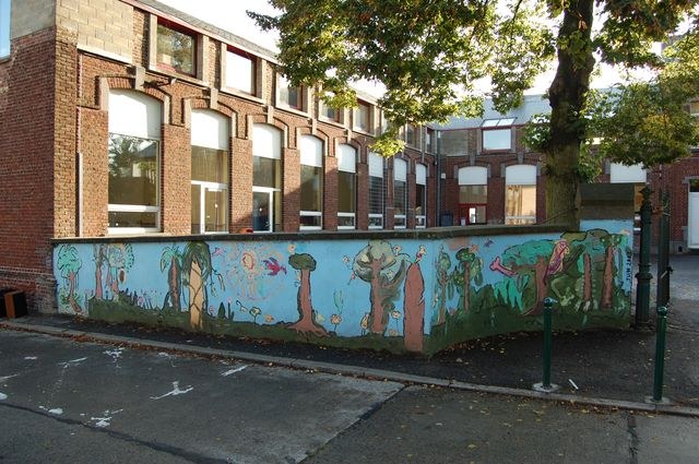 Détail de la fresque murale : des arbres peints le long du muret de la cour