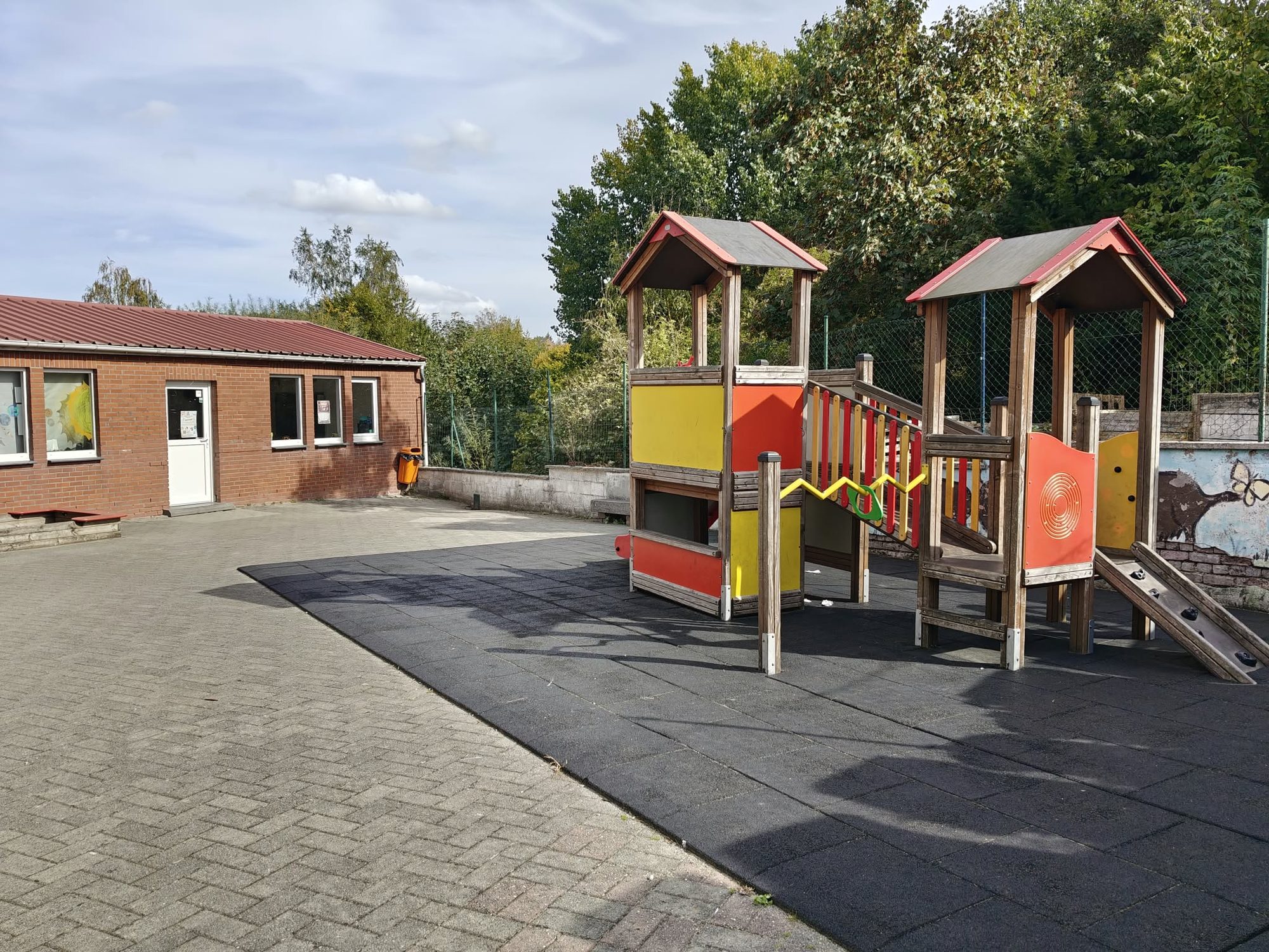 L’aire de jeux : un module en bois à deux tourelles, avec toboggan et sol souple
