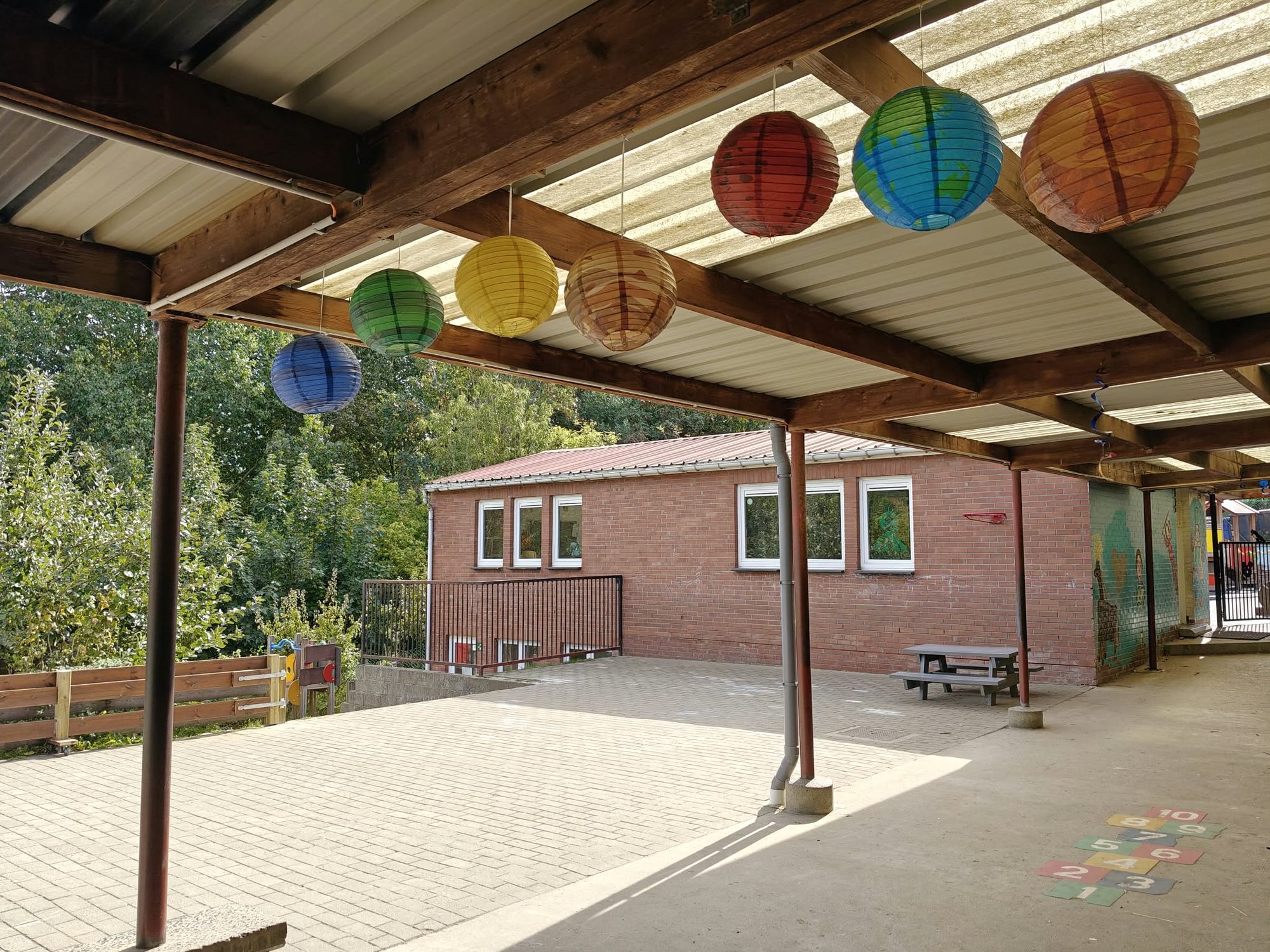 Le préau décoré de lampions colorés, devant le bâtiment des classes